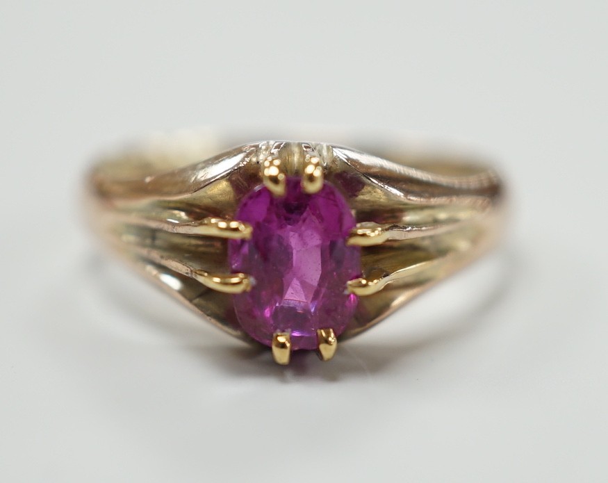 A yellow metal and claw set solitaire oval cut ruby/pink sapphire? ring, size L, gross weight 3.3 grams